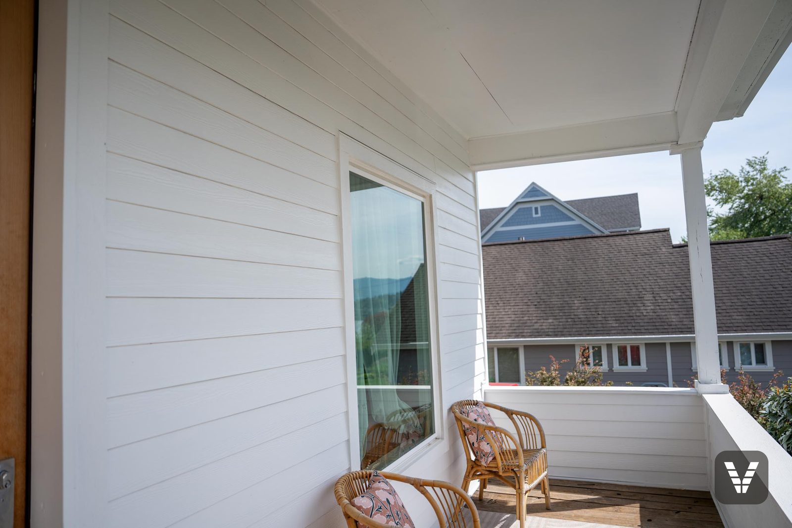 On the porch — fresh white lap and trim at the corner post