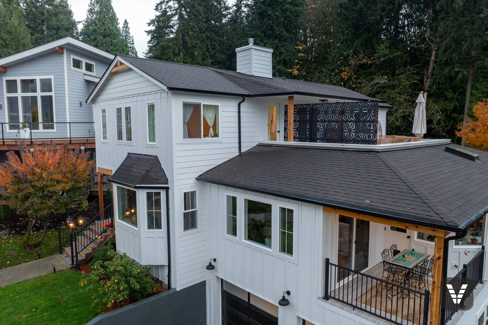 Drone view of the Arctic White board-and-batten front with the rooftop deck beyond — Siding & Window Vault project in Bellingham, WA