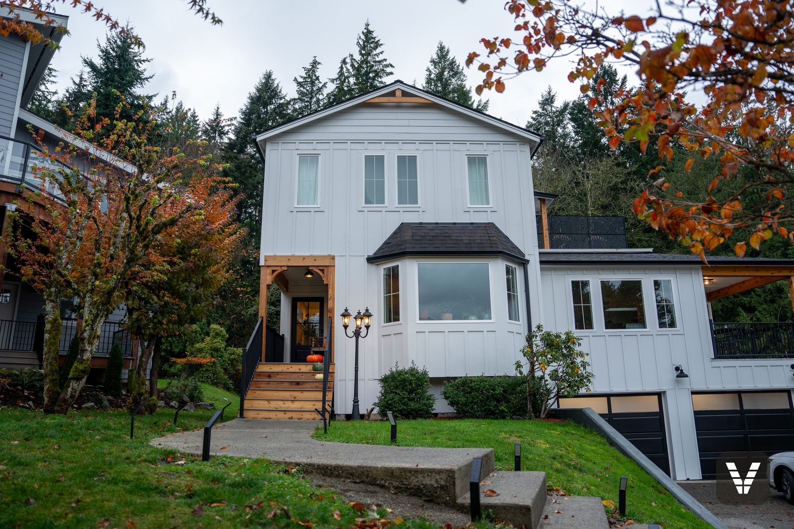 Front elevation in Arctic White board-and-batten with the new black fiberglass entry door — Siding & Window Vault project in Bellingham, WA