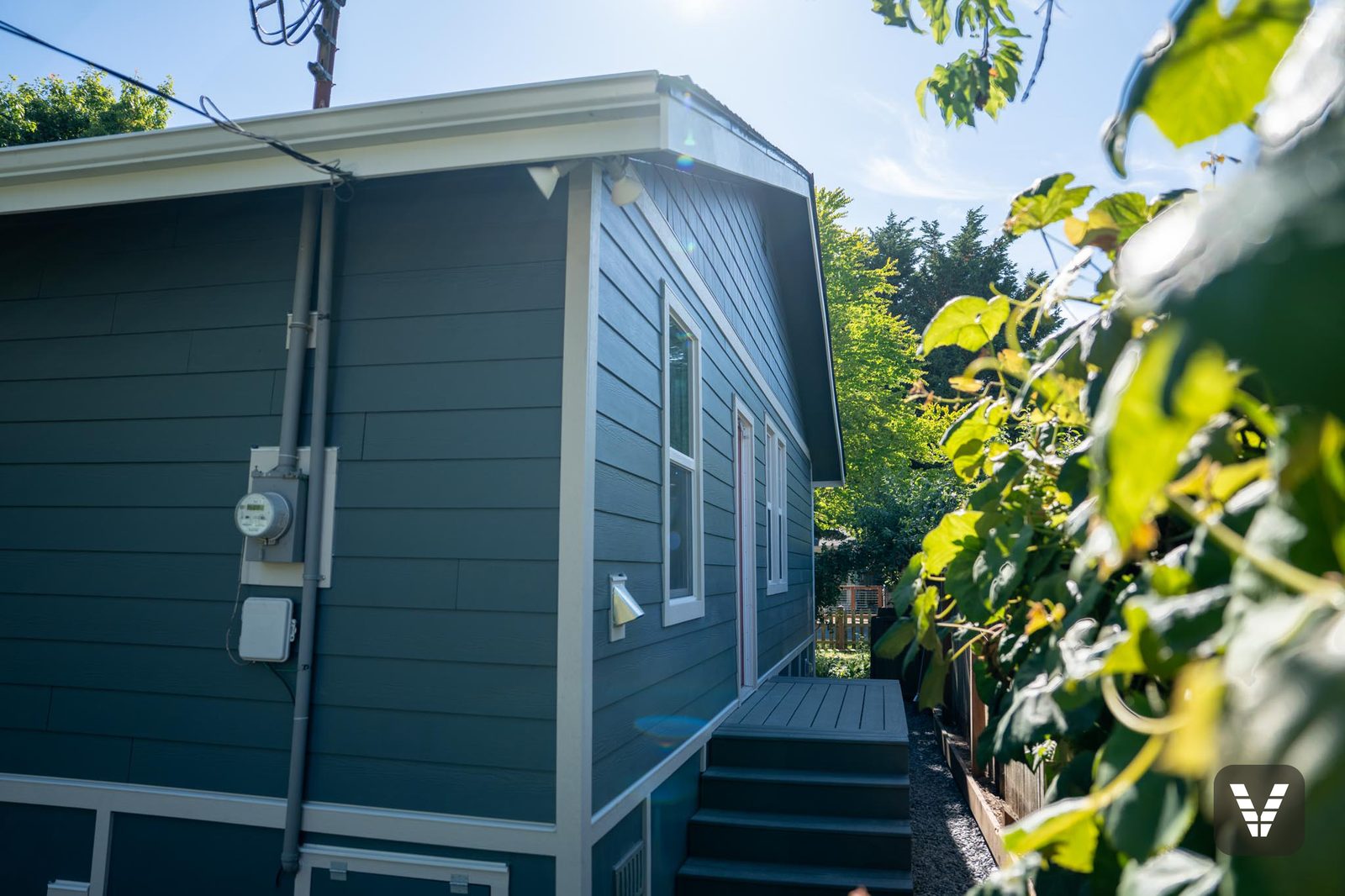 Side elevation — utilities remounted over fresh Evening Blue lap — Siding & Window Vault project in Bellingham, WA