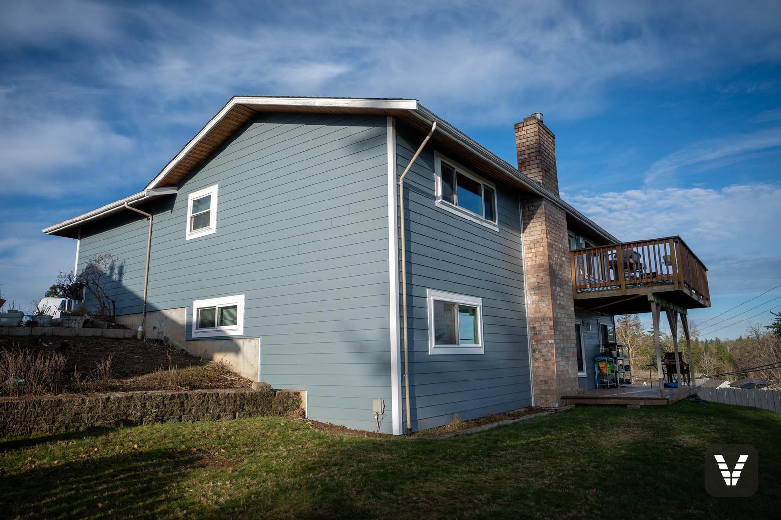 The chimney side in Boothbay Blue — the rear/side elevation from the yard — Siding & Window Vault project in Ferndale, WA