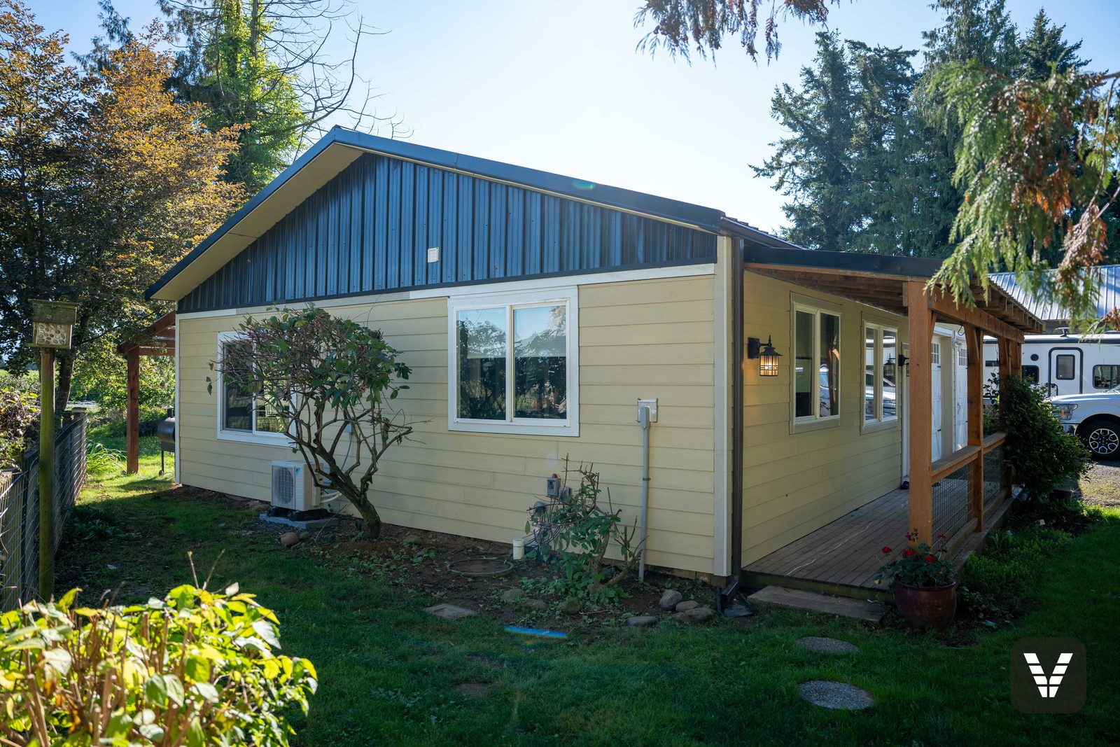 The guest house — fresh primed HardiePlank and trim under the cedar porch posts, ready for paint