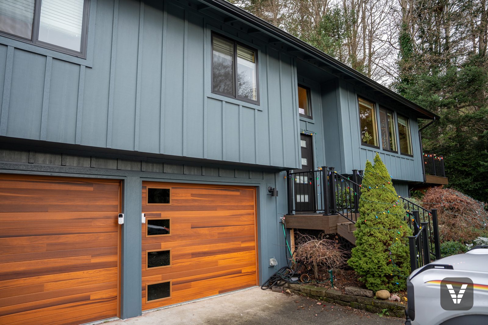 Completed James Hardie Evening Blue board-and-batten re-side with black Andersen windows in Anacortes, WA