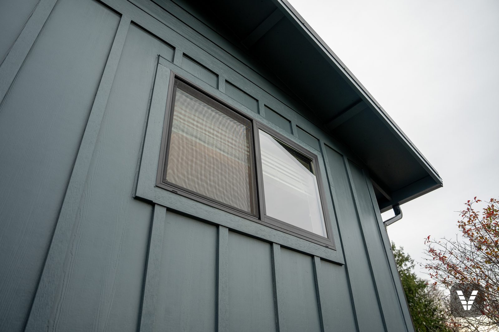 Window trim detail — dark-framed slider wrapped in Evening Blue HardieTrim