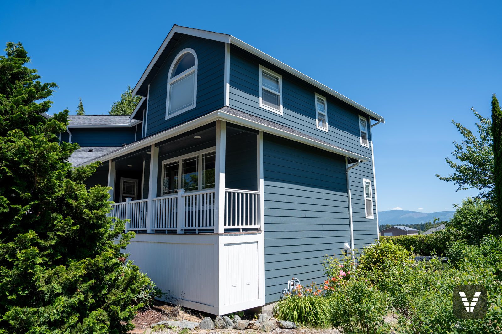 The wrapped porch corner and white skirting — Siding & Window Vault project in Bellingham, WA