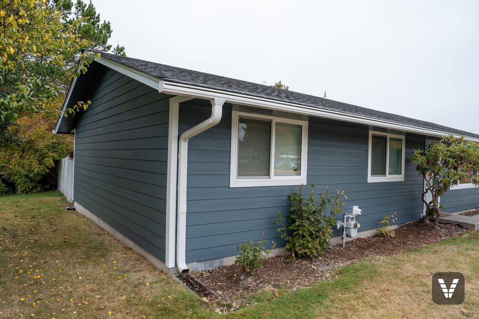 Front corner of the home with two of the new Milgard sliding windows trimmed in Arctic White