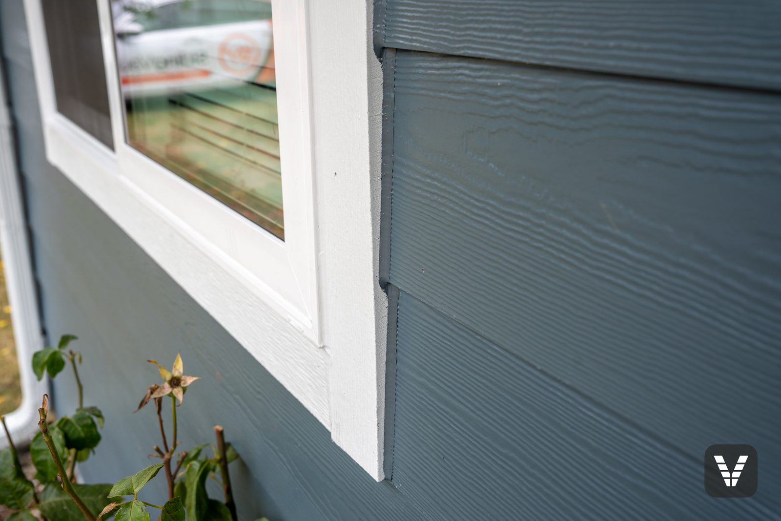 Close-up of Arctic White HardieTrim against Cedarmill-texture Evening Blue plank at a window corner