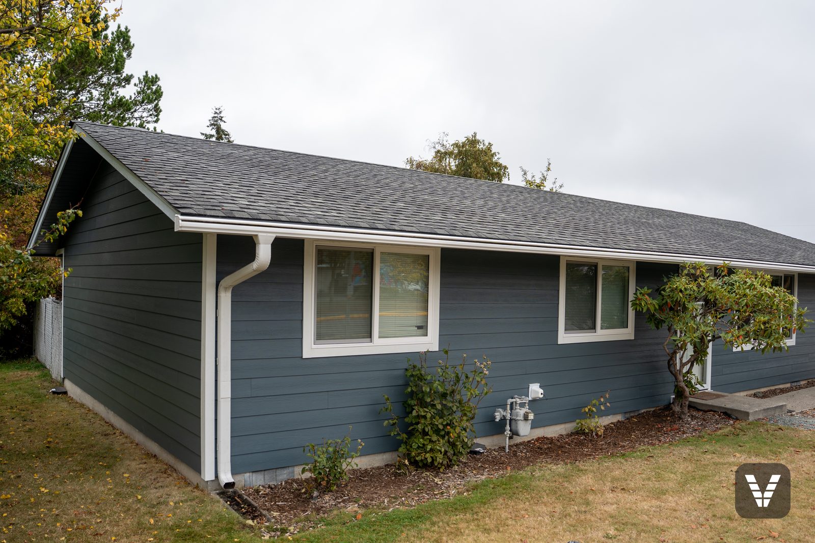 Finished Evening Blue James Hardie lap siding with Arctic White trim and new white Milgard windows on a single-story home in Anacortes, WA