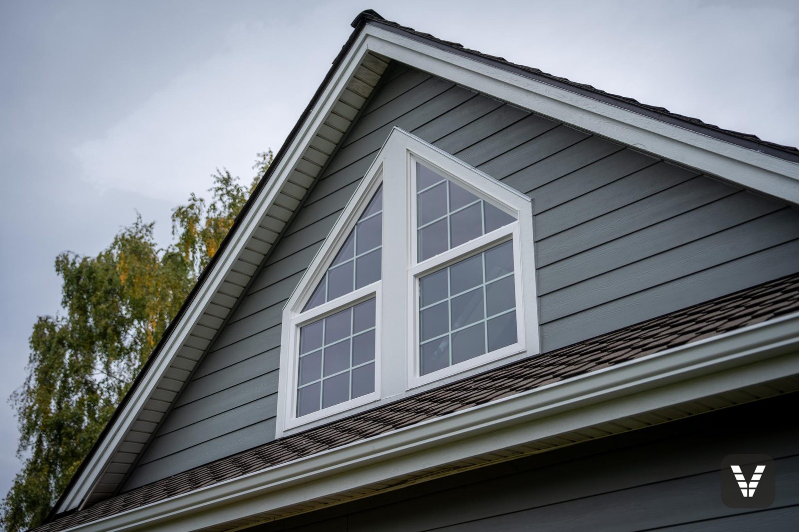 One of four custom PlyGem combination windows — a fixed picture pane above, an awning window below, fitted as a single unit in the gable