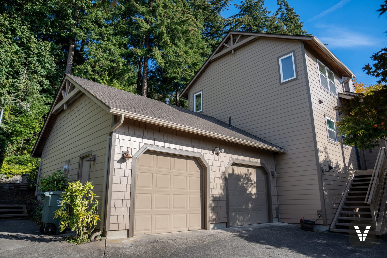 The garage and upper walls — straight-edge HardieShingle on the feature faces, lap on the tall walls, Timber Bark trim throughout