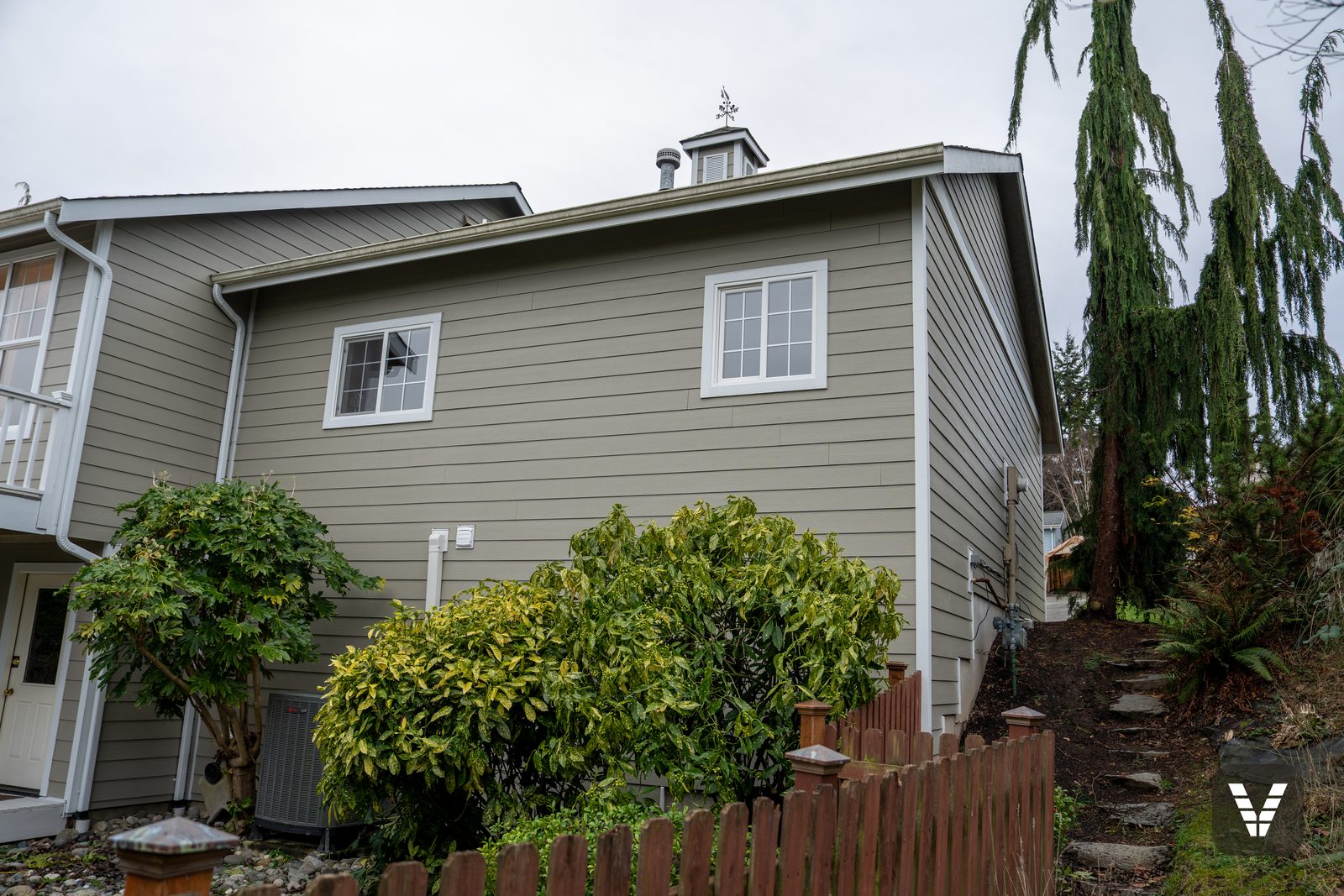 Rear corner with the cupola above fresh Monterey Taupe siding — Siding & Window Vault project in Anacortes, WA