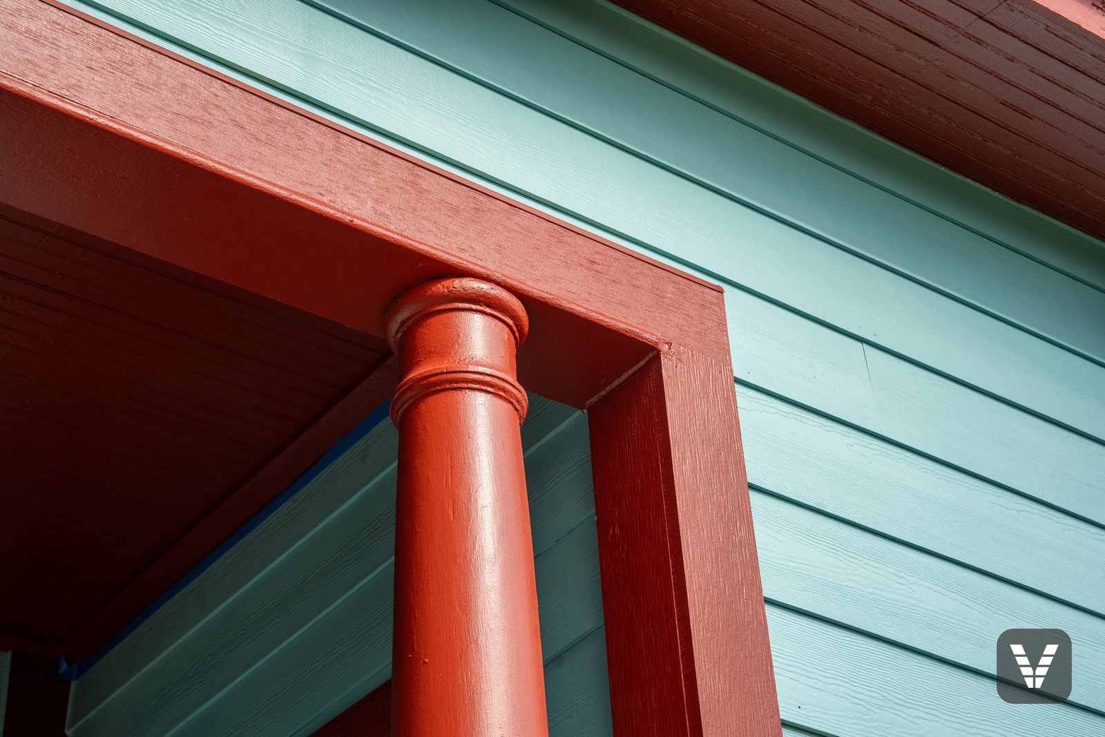 The porch column — turned wood restored and painted Fireweed against Reflecting Pool lap