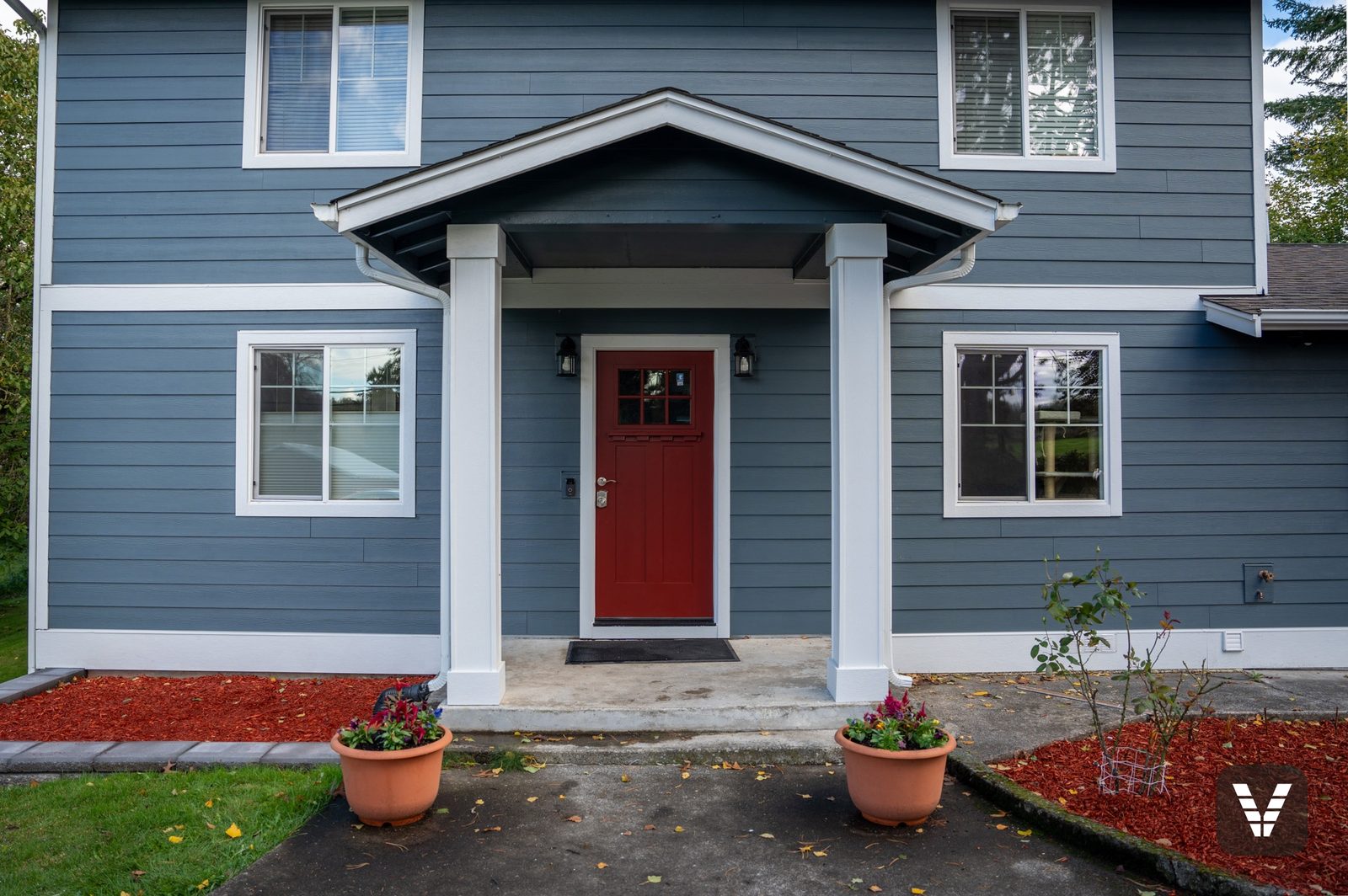 The entry bay straight on — red Codel craftsman door under the rebuilt porch