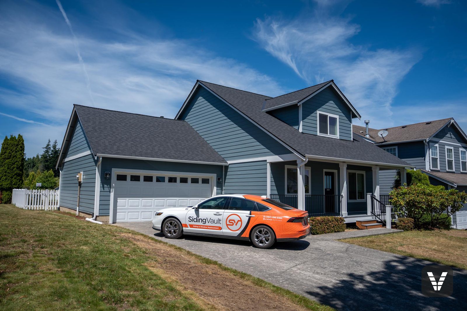 Completed Boothbay Blue James Hardie re-side with new white Milgard windows in Ferndale, WA — front three-quarter view