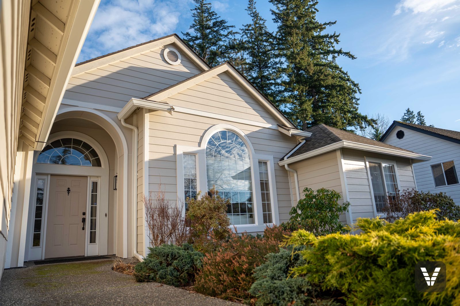 Finished Bellingham home in Cobble Stone James Hardie lap siding with Arctic White trim and arched feature windows after EIFS stucco removal